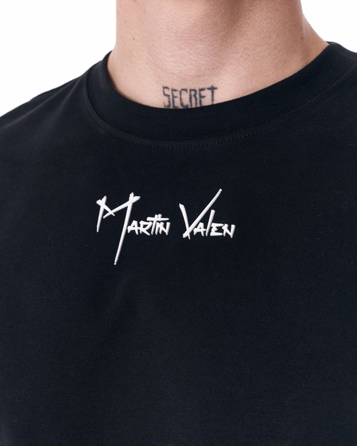 Martin Valen men's black half-sleeve T-shirt, waist-down view with hand in pocket highlighting hem and sleeve length