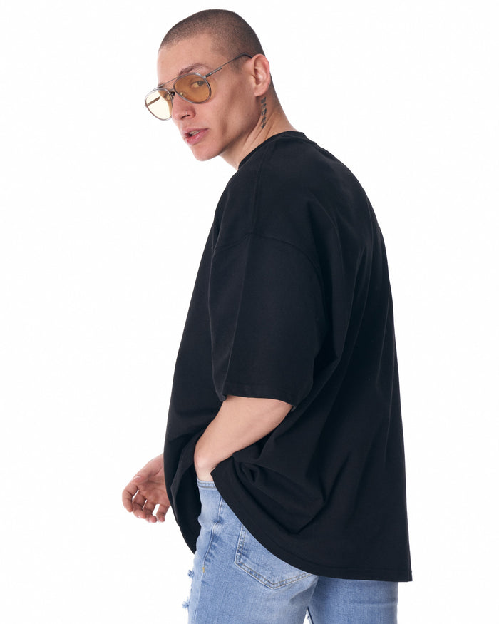Close-up of Martin Valen men's black half-sleeve T-shirt collar, partial white logo visible and ribbed neckline detail