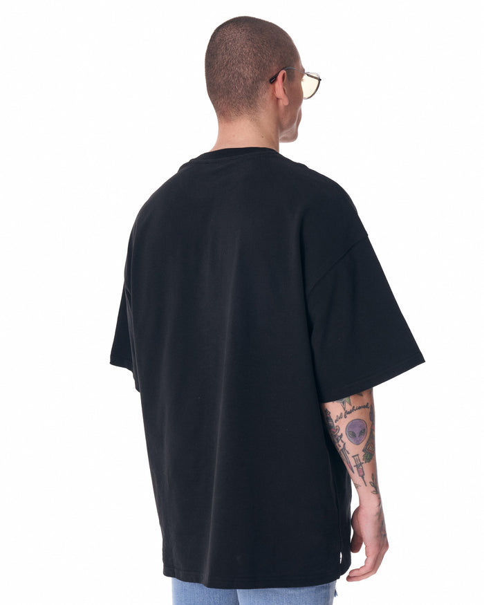 Martin Valen men's black half-sleeve T-shirt, full-length view showing half sleeves, ripped jeans and tattooed arm
