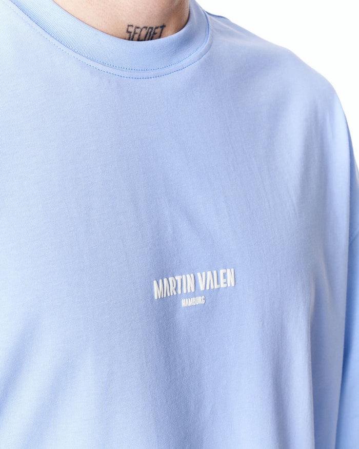 Martin Valen blue "Slogan" oversized men's T‑shirt close-up of chest, crew neck and small white Martin Valen logo on front